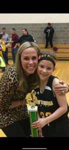Mother and daughter hugging with a trophy