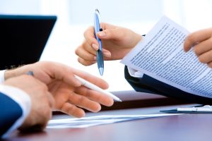 Two people fill out paperwork.