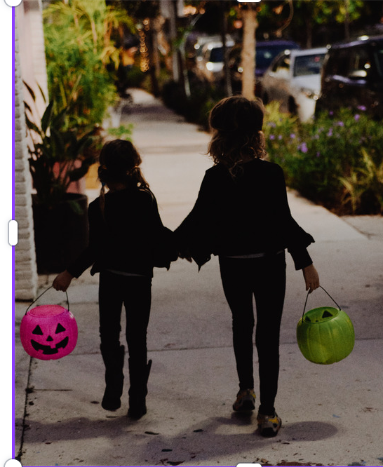 Two kids out trick-or-treating at night